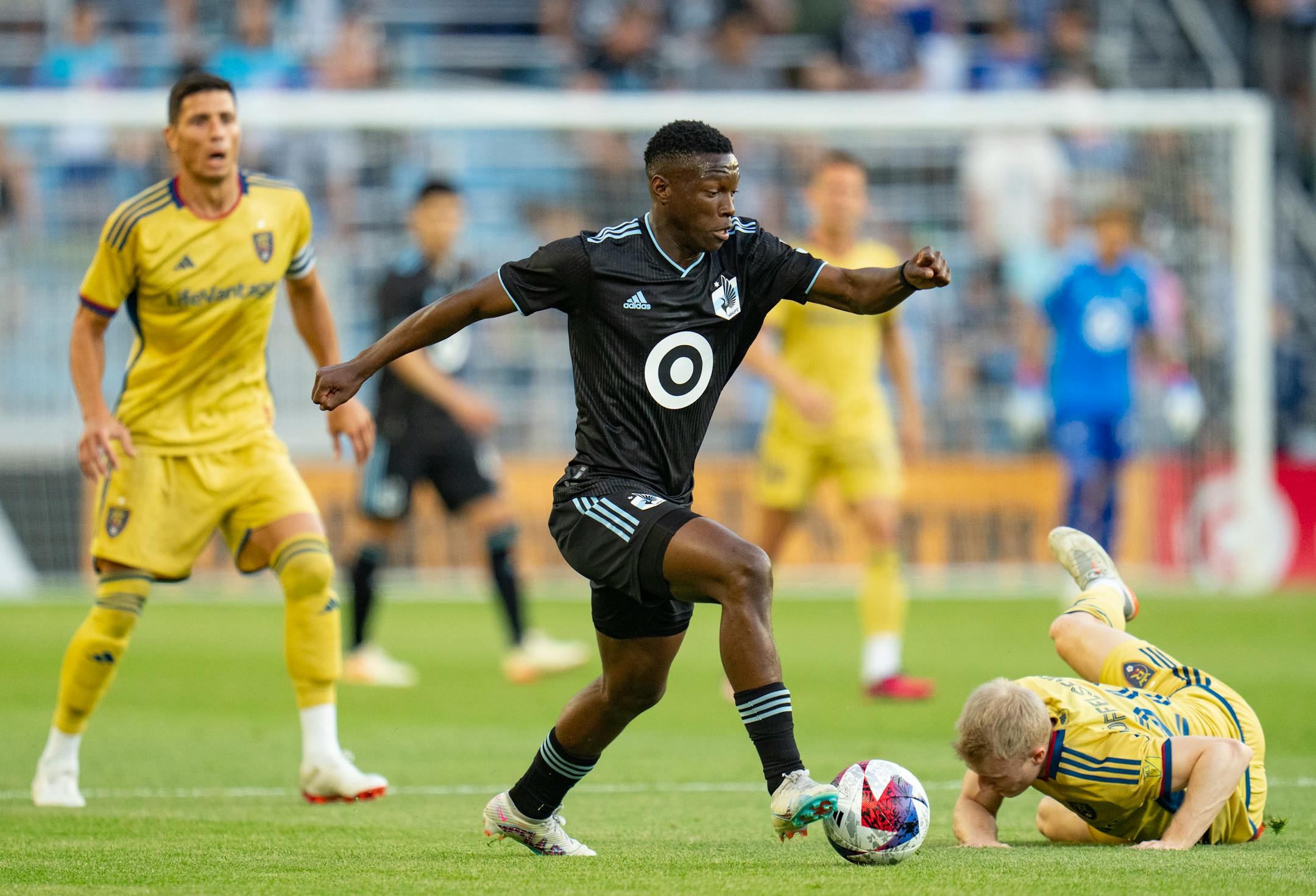 Minnesota United forward Bongokuhle Hlongwane (21) dribbles past Real Salt Lake defender Jasper Löffelsend (28) after he had fallen in the first half.
