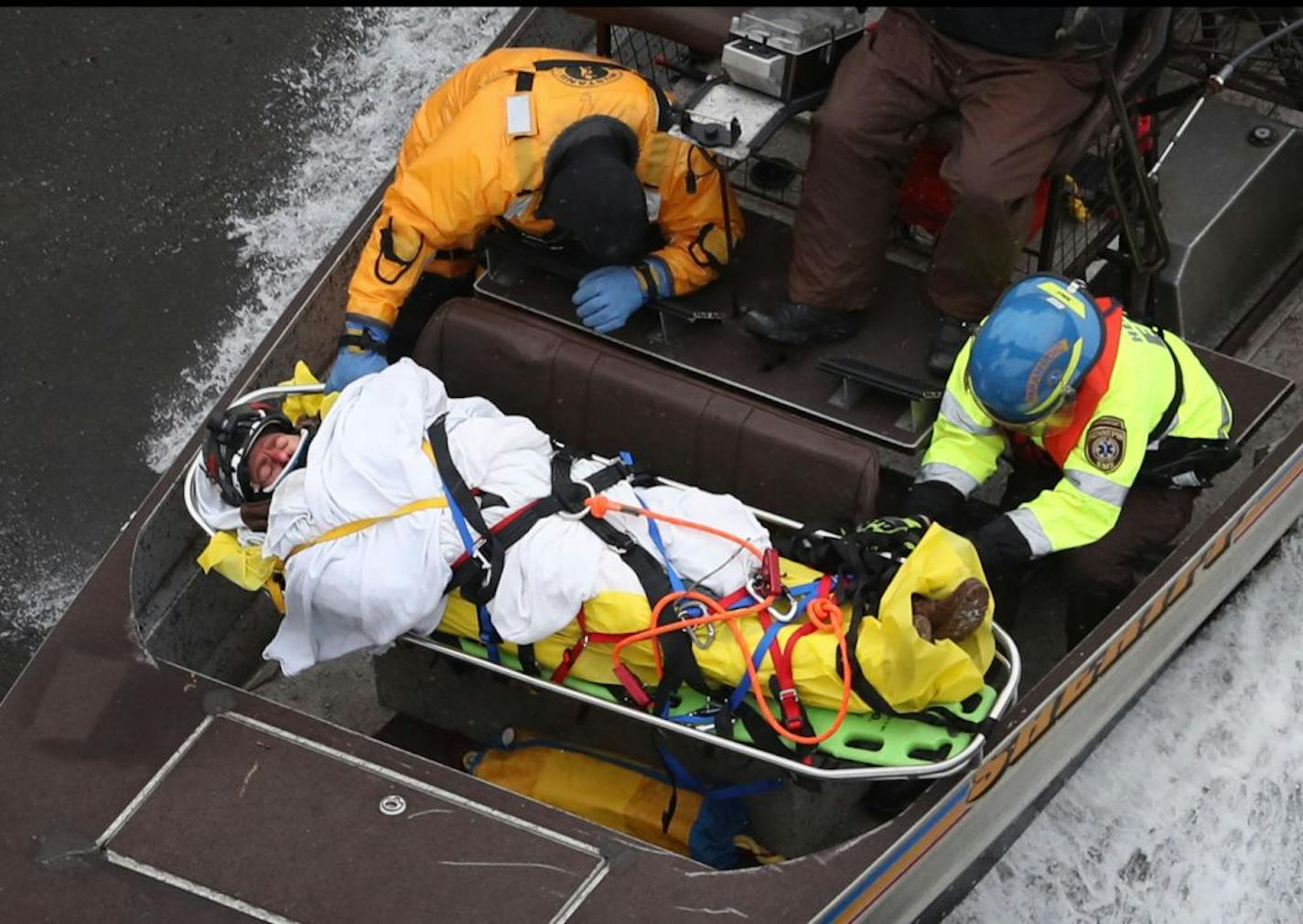 Rescue personnel transferring the victim by airboat down the Mississippi River, seen from the Franklin Avenue Bridge, Tuesday, Dec. 27, 2016, in Minneapolis.