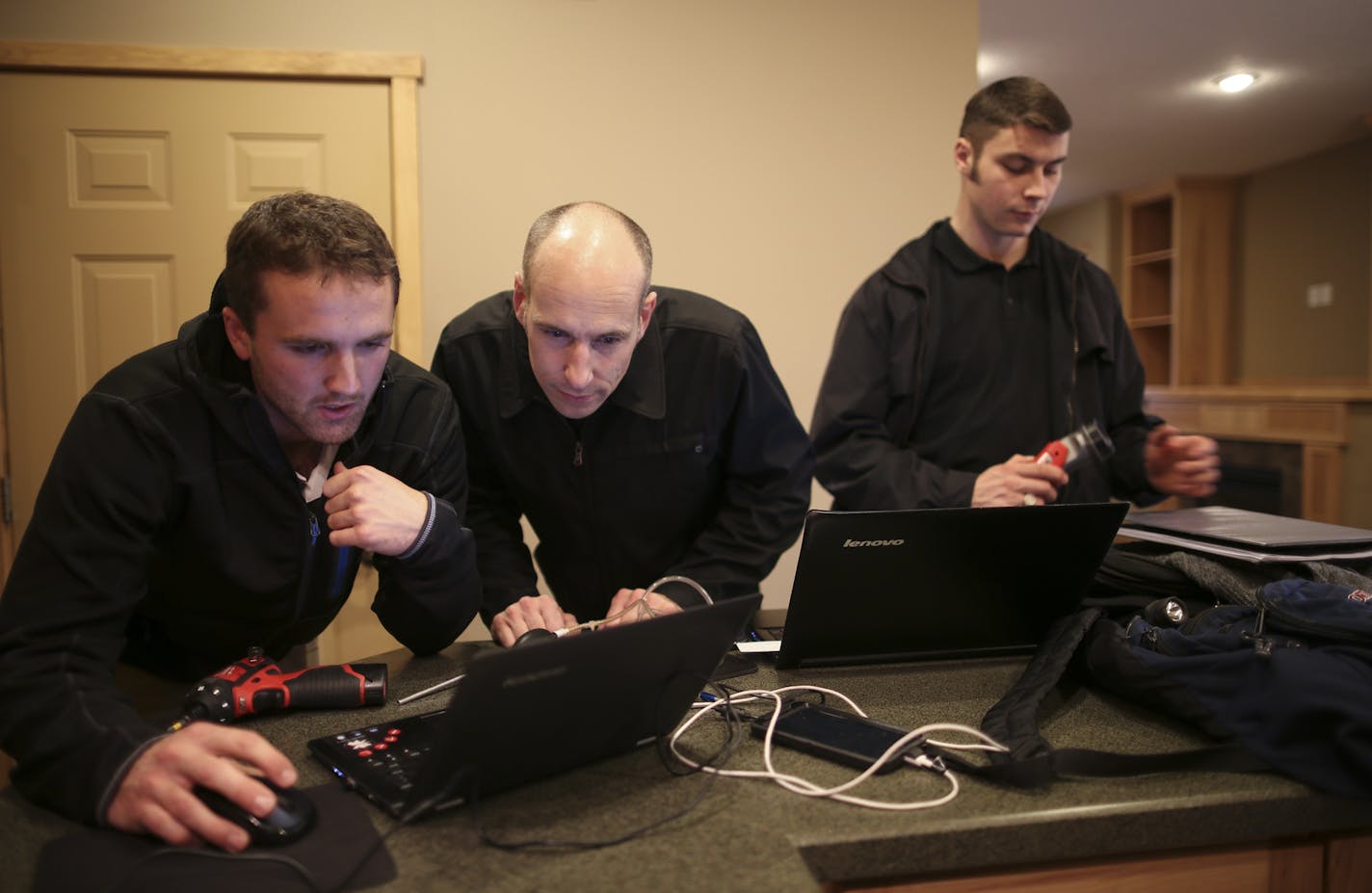 Matthew Brown, center, with apprentices Aaron Schroers, left, and Christopher Minwegen went over their inspection findings after they finished checking a home in Vadnais Heights for a buyer Monday afternoon. ] JEFF WHEELER &#xef; jeff.wheeler@startribune.com With home sales picking up housing inspectors are busier than they have been in a long while. Matthew Brown has taken on two apprentices in the last six months to help with the load. They inspected a townhome for a buyer Monday afternoon, No