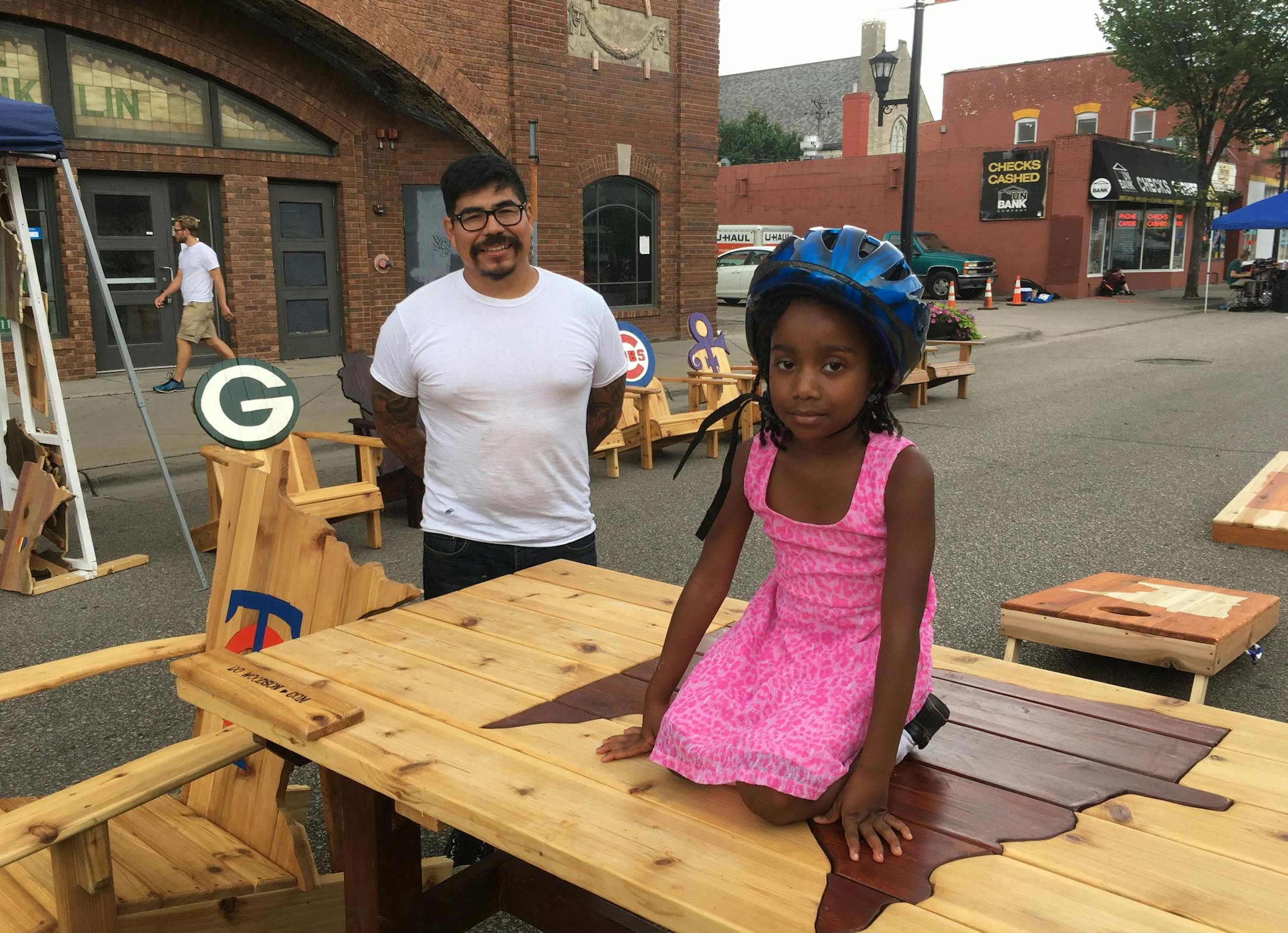 Open Streets Franklin visitor Sarojini Pokawa sat on a table made by south Minneapolis woodworker Manny Moreno.