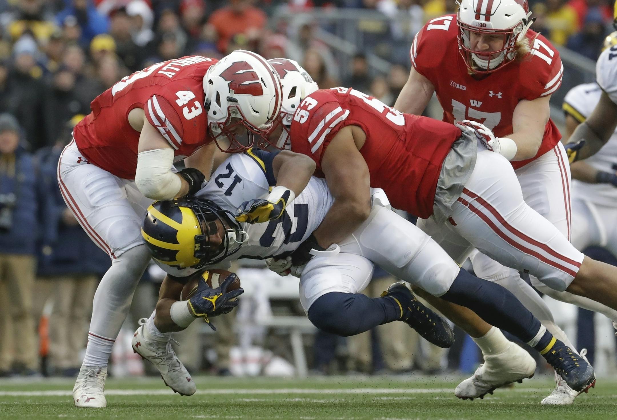Michigan's Chris Evans is stopped by Wisconsin's Ryan Connelly (43), T.J. Edwards and Andrew Van Ginkel during the second half of an NCAA college football game Saturday, Nov. 18, 2017, in Madison, Wis. (AP Photo/Morry Gash)