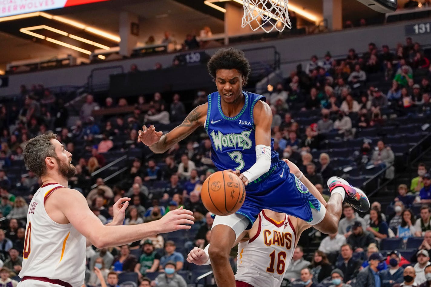 Minnesota Timberwolves forward Jaden McDaniels (3) is fouled by Cleveland Cavaliers forward Cedi Osman (16) while going up to shoot as Cavaliers forward Kevin Love, left, looks on during the first half of an NBA basketball game Friday, Dec. 10, 2021, in Minneapolis. (AP Photo/Craig Lassig)