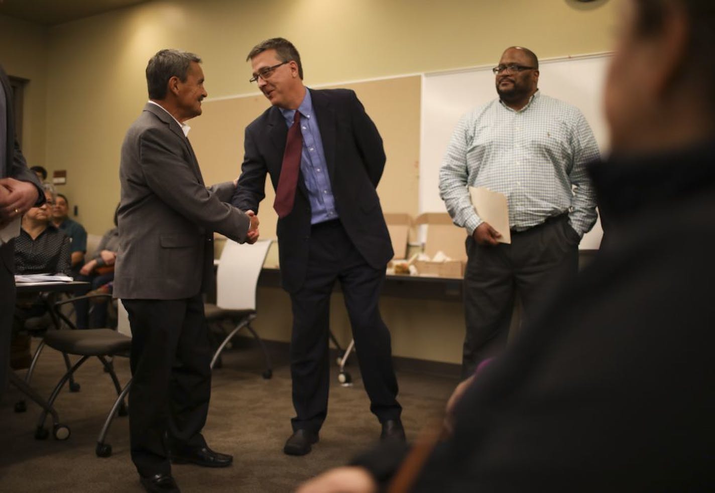 Richfield Mayor Pat Elliott, left, shook hands with Eric Schnell, COO of Aeon, after Elliott told the roomful of people there to attend a city council work session on affordable housing that Aeon would be buying the Seasons Park apartment complex in the city. That was good news for the City of Richfield as Aeon is a non-profit developer that creates affordable housing in the Twin Cities.