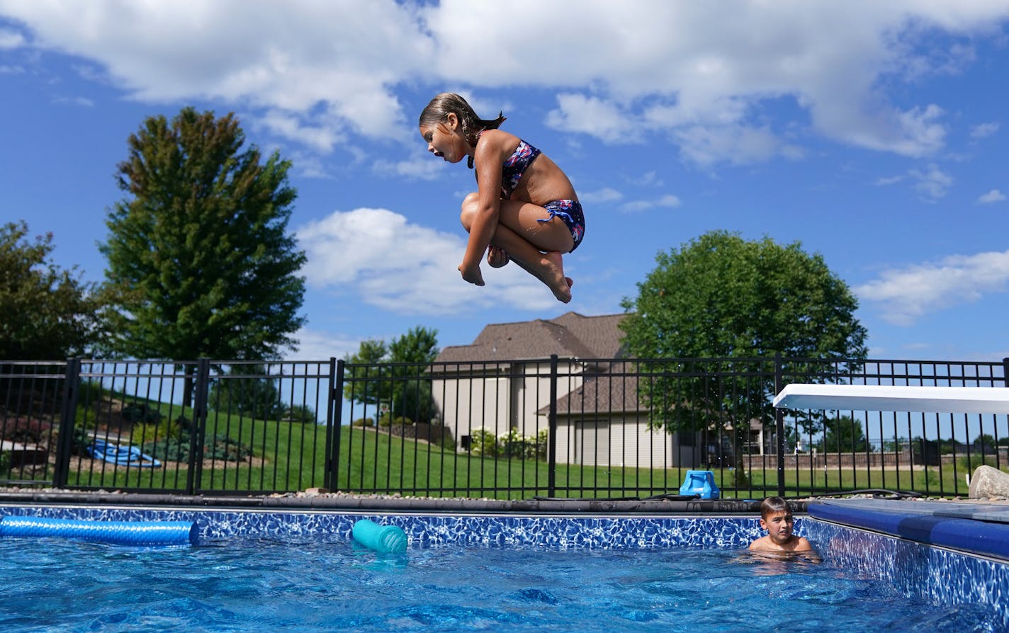 Isla Lemcke, 5, did a canon ball off the diving board in the deep end of her family's newly installed in-ground pool Tuesday. ] ANTHONY SOUFFLE • anthony.souffle@startribune.com The Lemcke family swam in their newly installed in-ground pool together Tuesday, Aug. 4, 2020 at their home in Ramsey, Minn.