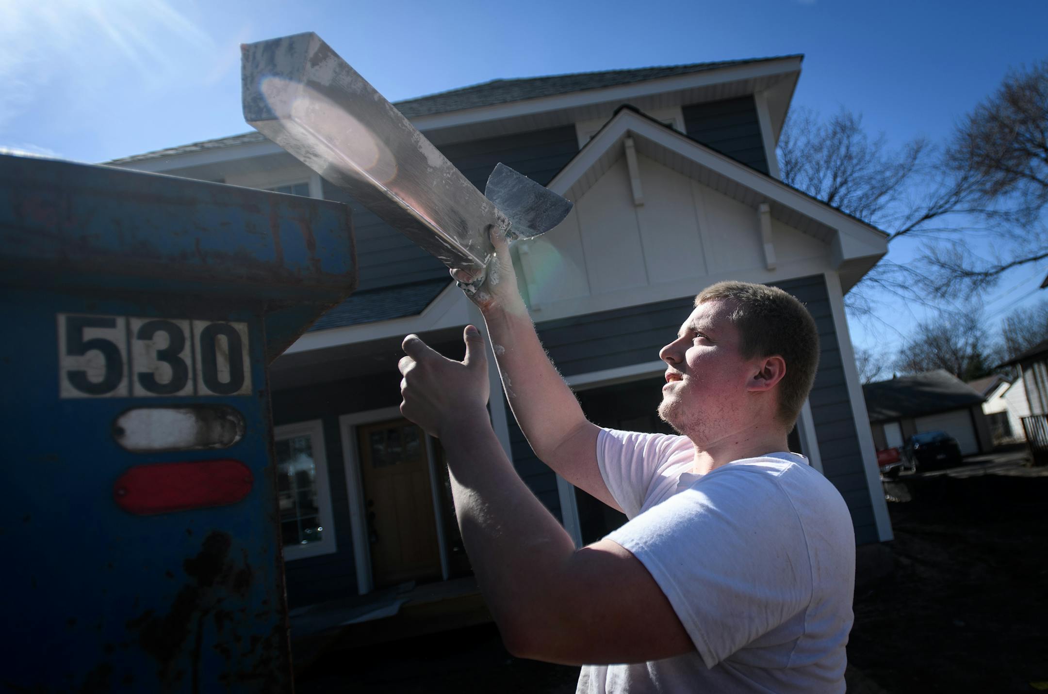 Mike Marotzke, of St. Paul, dumped joint compound into a dumpster as he worked on fire taping the drywall in the garage of an almost-completed home in northeast Minneapolis Friday afternoon. ] AARON LAVINSKY &#xef; aaron.lavinsky@startribune.com Housing construction -apartments and single-family houses - in the Twin Cities metro soared during March, according to a monthly report from the Builders Association of the Twin Cities. Realtor Chris Harrington showed prospective buyers an almost-finishe
