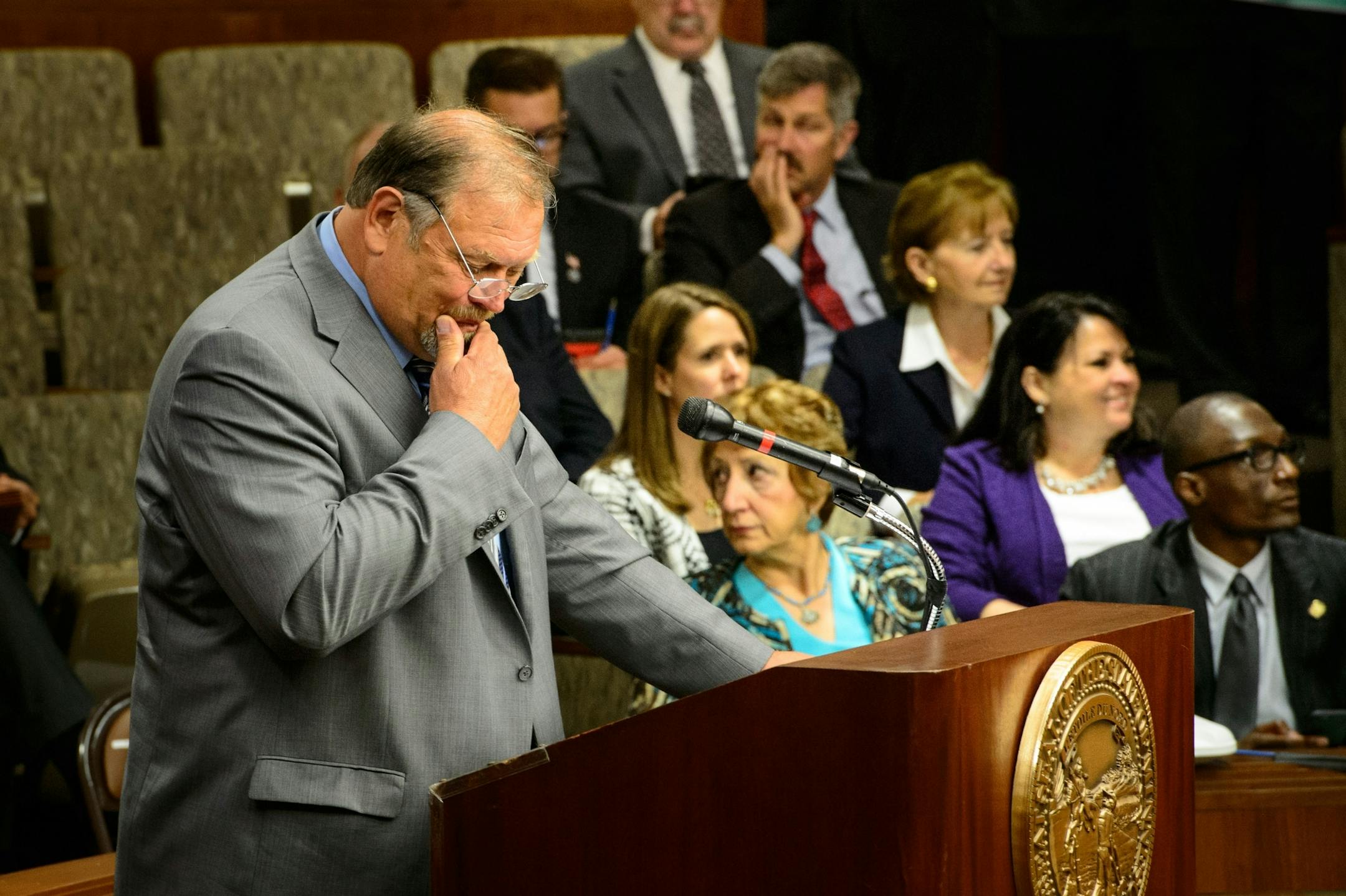 Senate Majority Leader Tim Bakk looked over notes at the start of the session, DFL Senators are in the background. Many said they would not be supporting the environment bill.