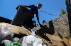 Ryan Hubner of 1-800-Got-Junk offloads a trashcan onto a garbage truck at the Lake Hiawatha cleanup spot. ] Timothy Nwachukwu &#x2022; timothy.nwachuk