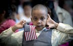 Abdirahman Ahmed listened to speakers during a U.S. Citizenship and Immigration Services citizenship ceremony at the Minnesota Children's Museum, Frid