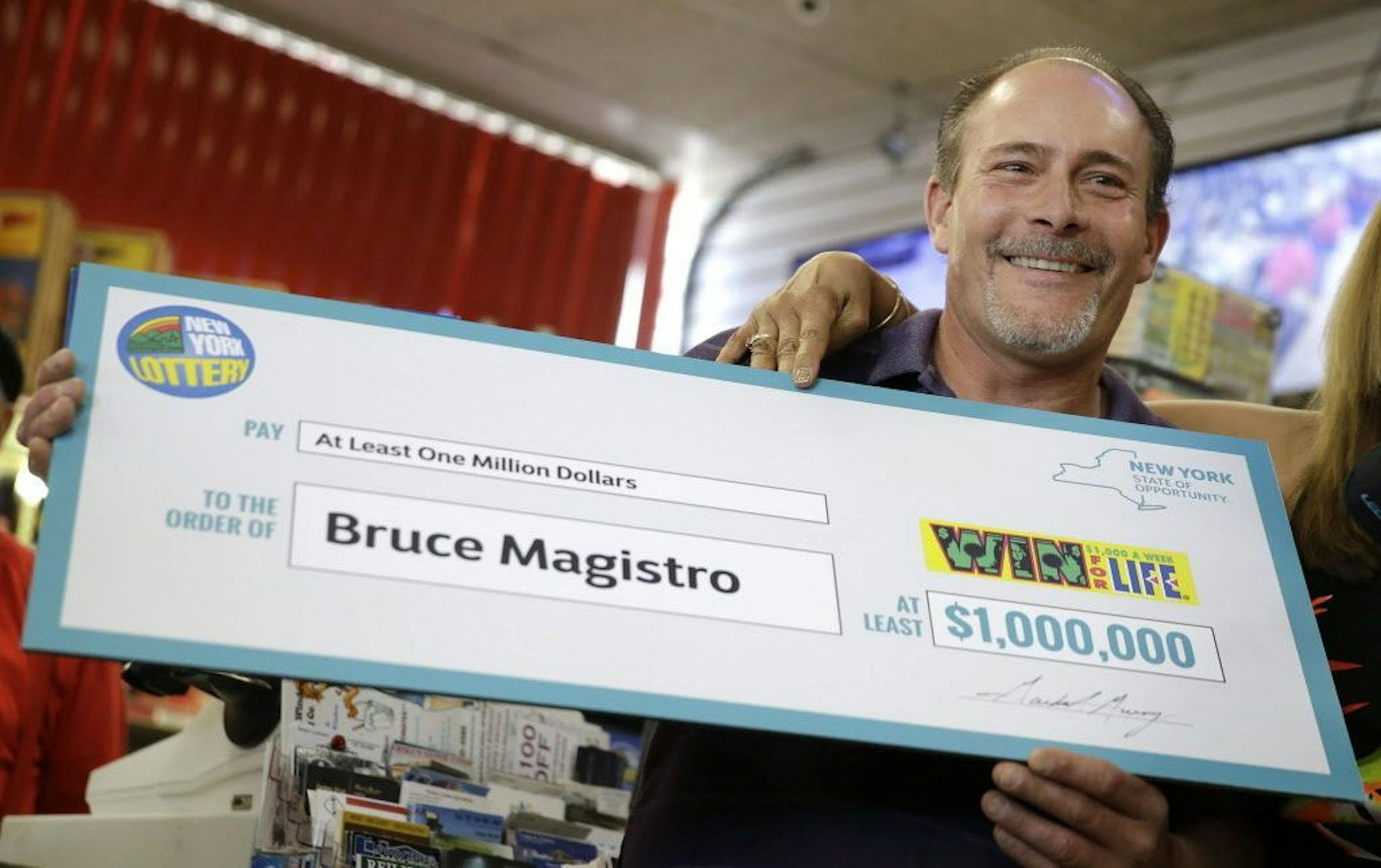 Bruce Magistro holds up a check while talking to reporters about winning $1 million in the New York Lottery for a second time during a news conference in Babylon, N.Y., Wednesday, May 11, 2016. Lottery officials revealed Magistro as the two-time lottery winner.