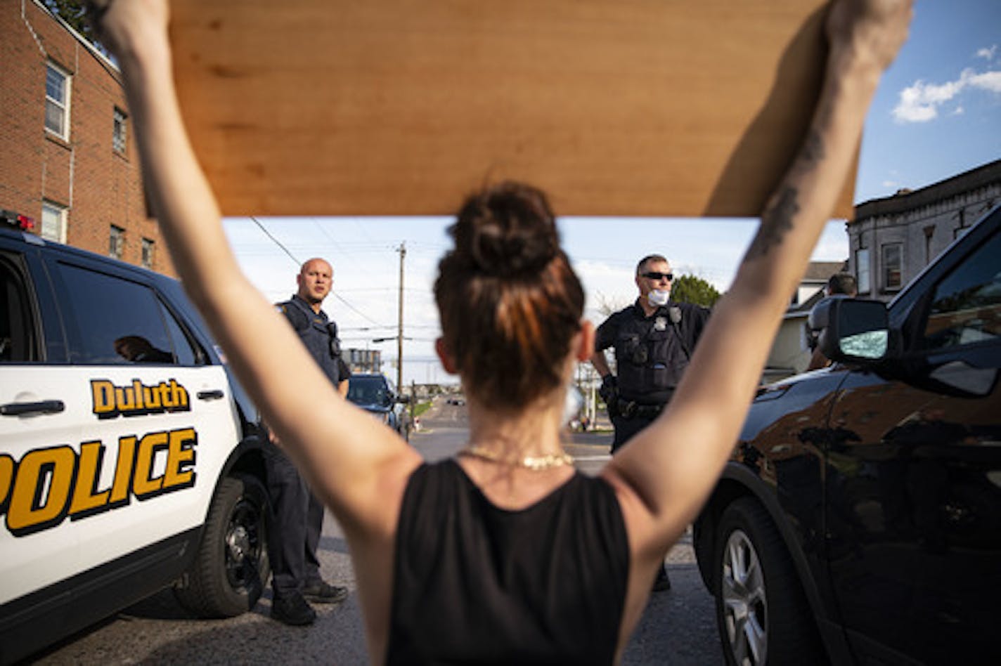 Brayleigh Keliin held a sign with dozens of names of black people who died from police force in front of Duluth Police officers on 21st Ave E in Duluth, MN on Wednesday. ] ALEX KORMANN • alex.kormann@startribune.com Over 100 people showed up on the corner of London Rd and 21st Ave E in Duluth, MN on Wednesday May 27, 2020 to protest the death of George Floyd. Protestors started by chanting on the corners and eventually shut down the intersection and marched down London Rd.