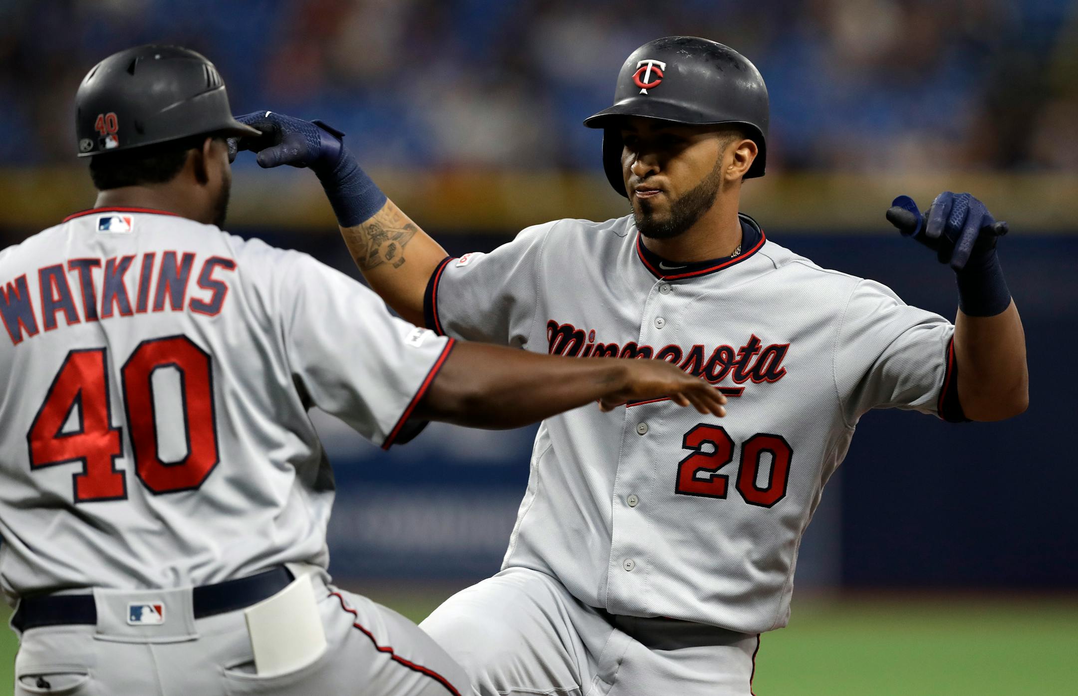 The Twins' Eddie Rosario celebrates his two-run single off Tampa Bay relief pitcher Adam Kolarek with first base coach Tommy Watkins