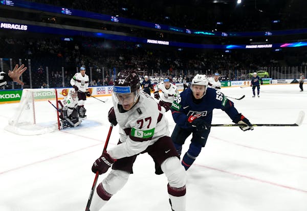 Kristaps Zile, left, of Latvia and Ben Meyers of Team USA chased the puck in the IIOHF Wordld Championship in Tampere, Finland, last Friday.