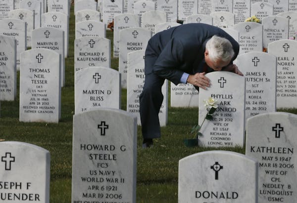 Richard Coonrod kissed the headstone marking the burial site of his wife, Phyllis Coonrod, at Fort Snelling National Cemetery. She died Dec. 28, 2012.