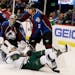 Minnesota Wild left wing Zach Parise, front, falls to the ice after being hit by Colorado Avalanche defensman Nick Holden while redirecting a shot on 