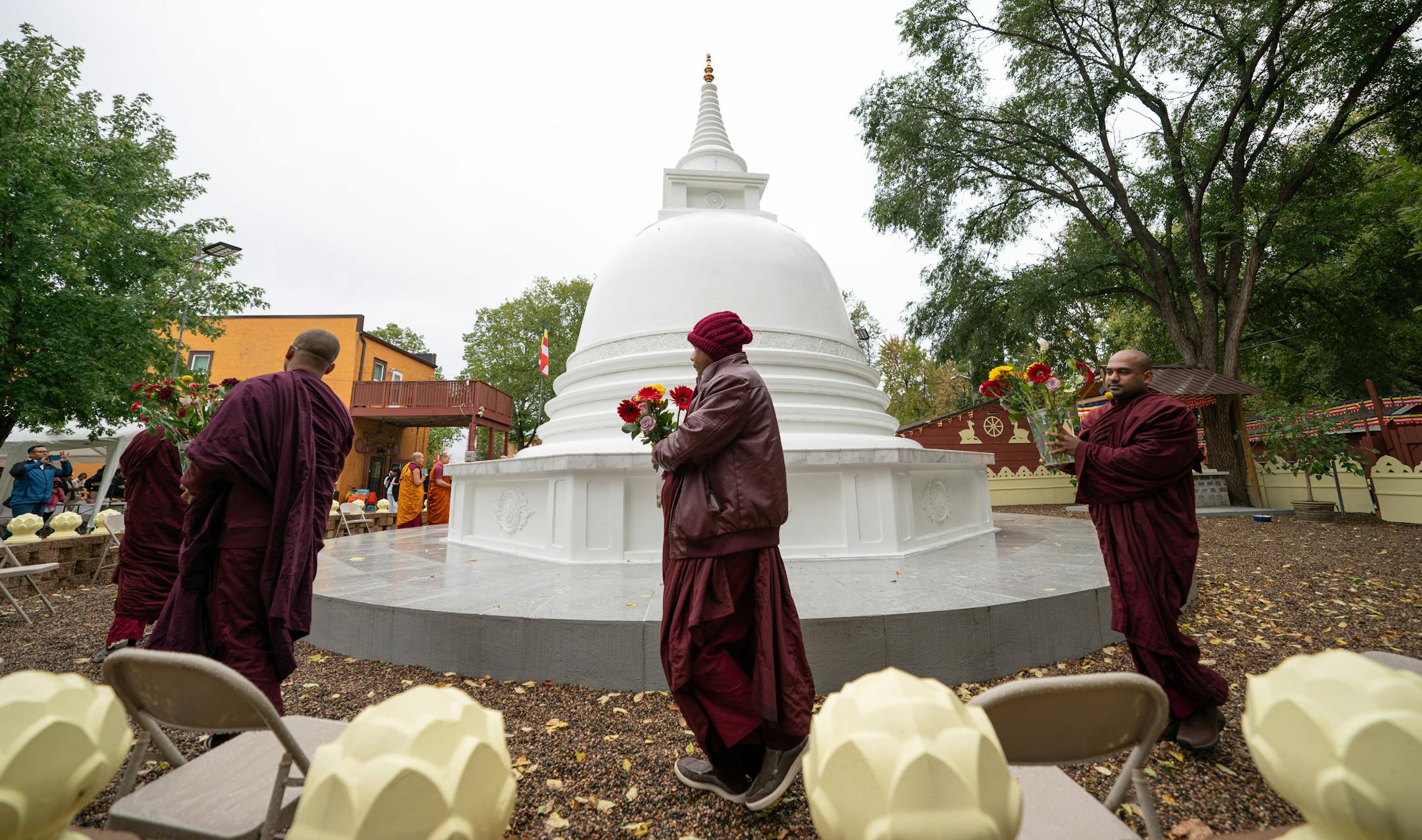 Visiting monks brought flowers to be placed on the Stupa Friday, Oct. 6, 2023 Minneapolis, Minn. This Stupa Unveiling marks a significant milestone in the history of Minnesota Buddhist Vihara and is an occasion of great joy and appreciation. A Stupa is a large white cement dome topped with a brass pinnacle. A sacred stupa is a physical structure in which a relic of the Buddha, enlightened beings, or holy books is enshrined. It creates an opportunity for people to circumambulate and cultivate positive vibration and spiritual development. ] GLEN STUBBE • glen.stubbe@startribune.com