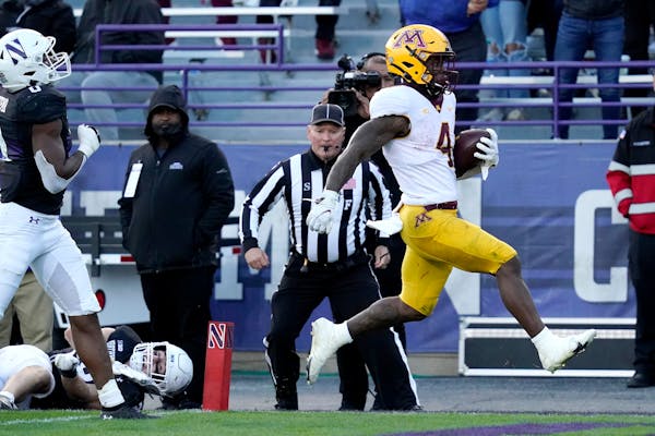 Minnesota running back Mar'Keise Irving, right, scores a touchdown past Northwestern linebacker Chris Bergin and defensive back Coco Azema during the 