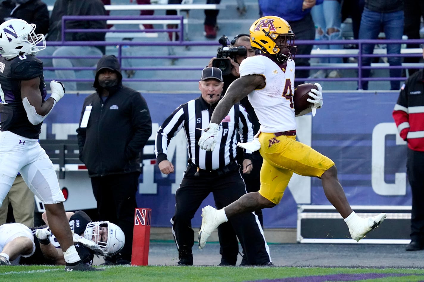 Minnesota running back Mar'Keise Irving, right, scores a touchdown past Northwestern linebacker Chris Bergin and defensive back Coco Azema during the second half of an NCAA college football game in Evanston, Ill., Saturday, Oct. 30, 2021. (AP Photo/Nam Y. Huh)