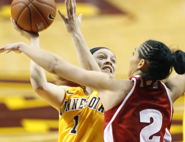 Minnesota's Rachel Banham went up to score despite pressure from Wisconsin's Taylor Wurtz at Williams Arena, Thursday, January 23, 2014 in Minneapolis