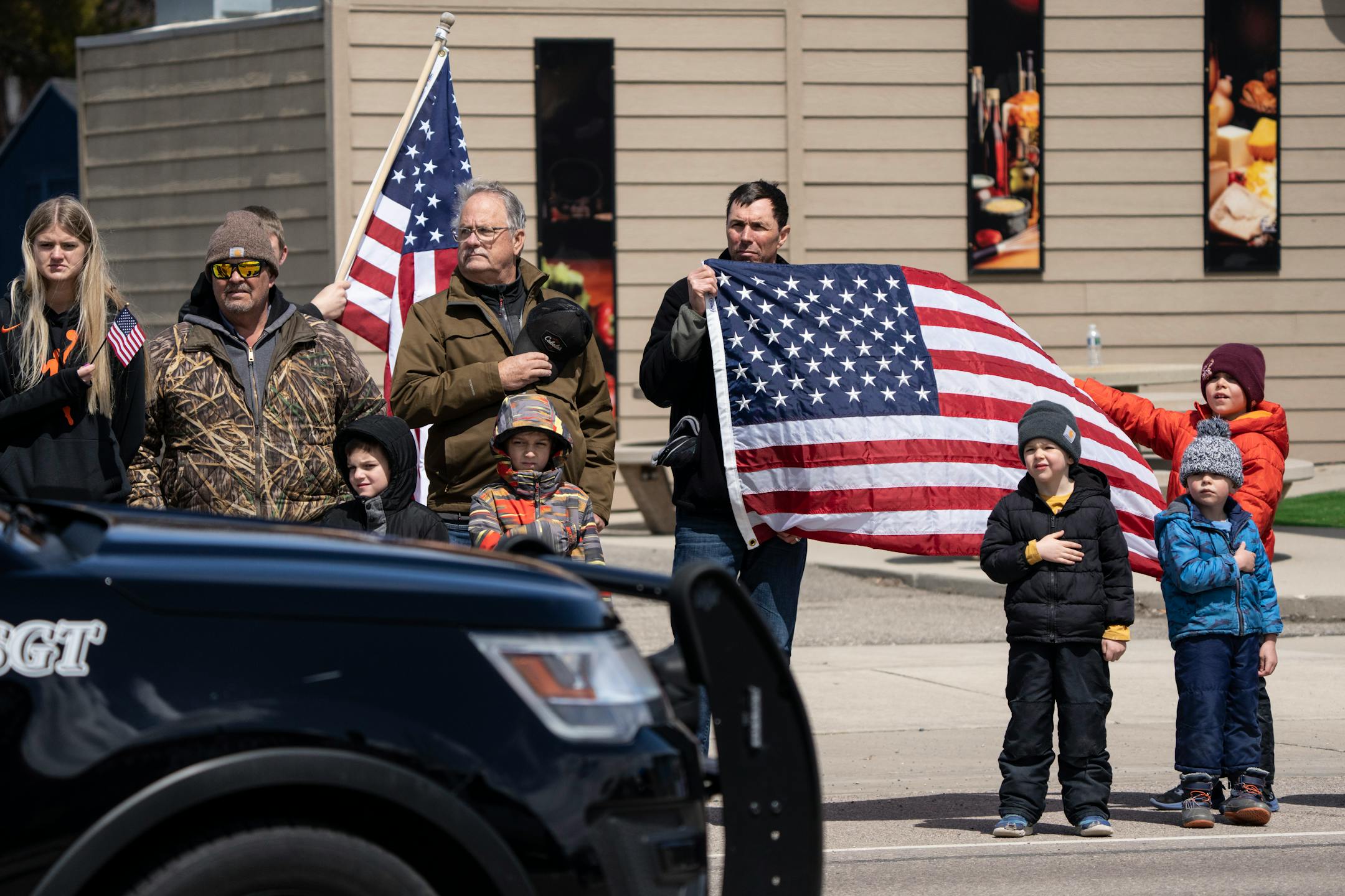 People line the streets of downtown Glenwood for the funeral procession after the visitation and funeral of Pope County deputy Josh Owen.