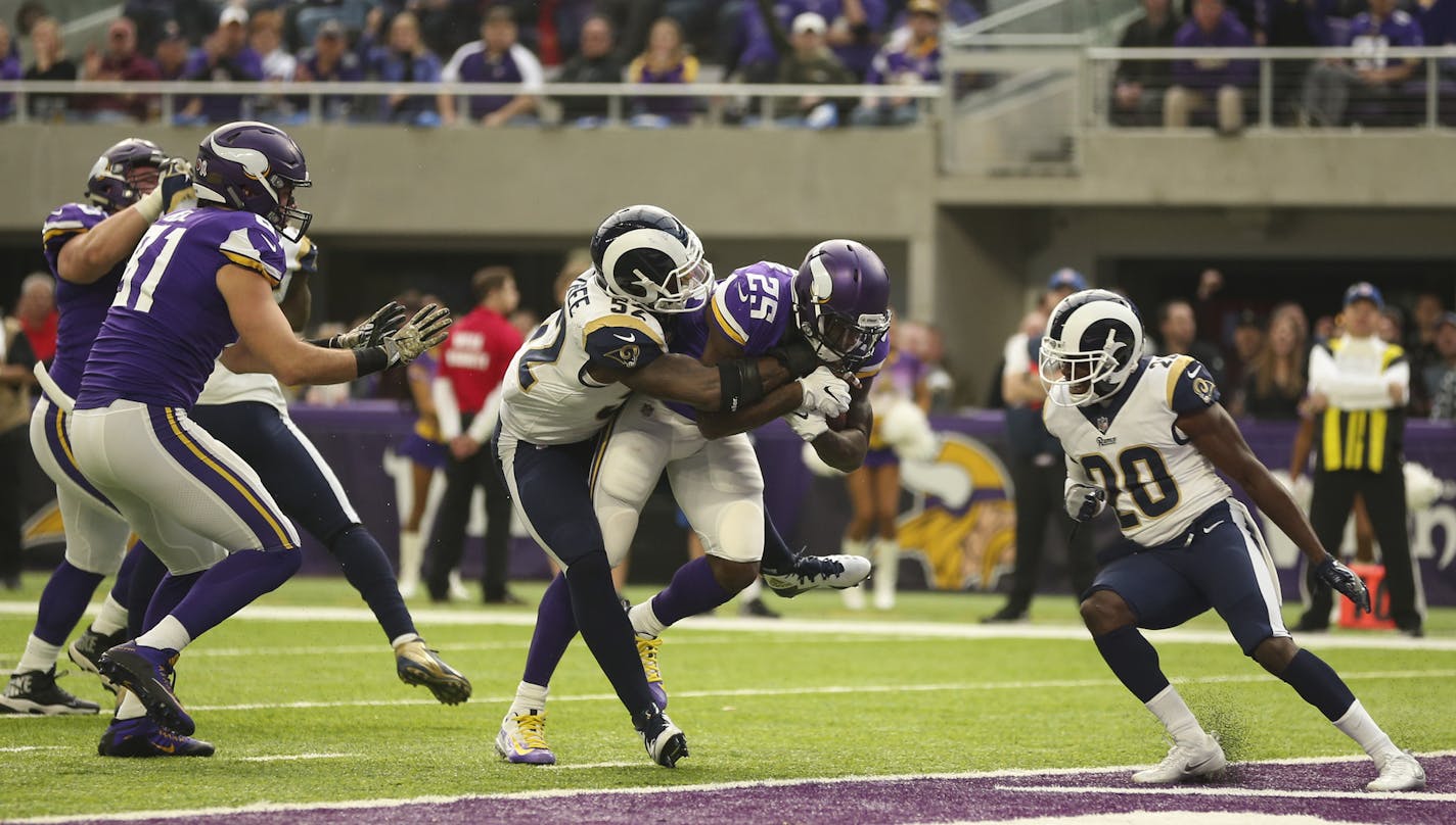 Minnesota Vikings running back Latavius Murray (25) dragged Los Angeles Rams inside linebacker Alec Ogletree (52) with him into the end zone on an eight yard run in the second quarter.