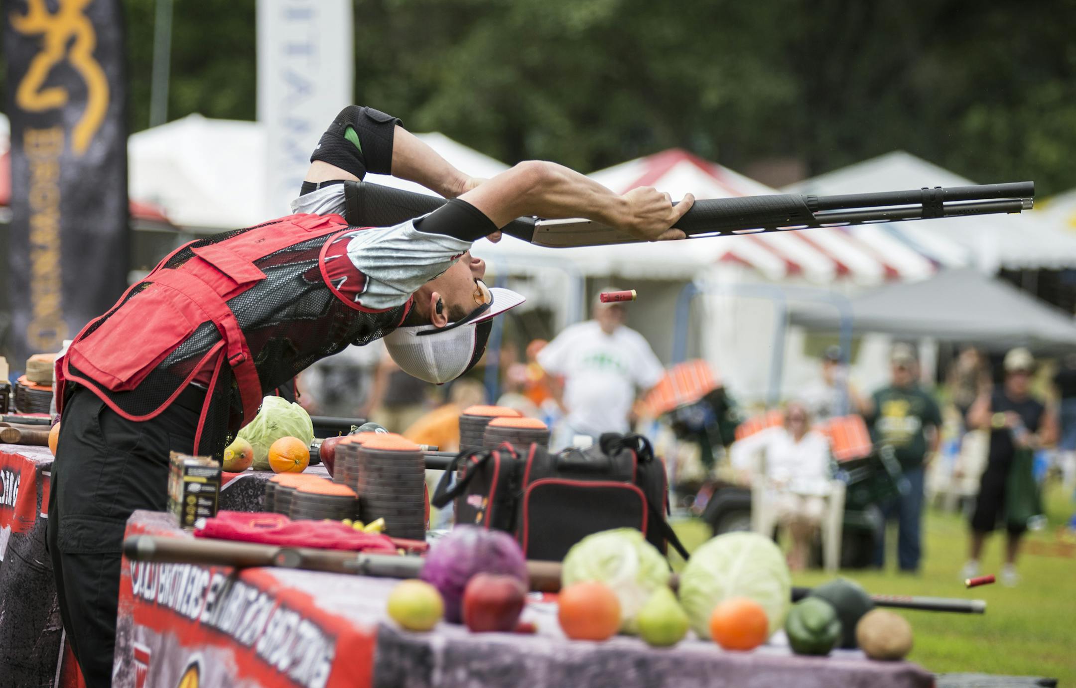 Steve Gould of Alexandria, Minn., half of the duo that makes up Gould Brothers Exhibition Shooting, demonstrates clay shooting while upside down during a trick shooting exhibition at the Game Fair in Ramsey on Friday, August 7, 2015. ] LEILA NAVIDI leila.navidi@startribune.com /