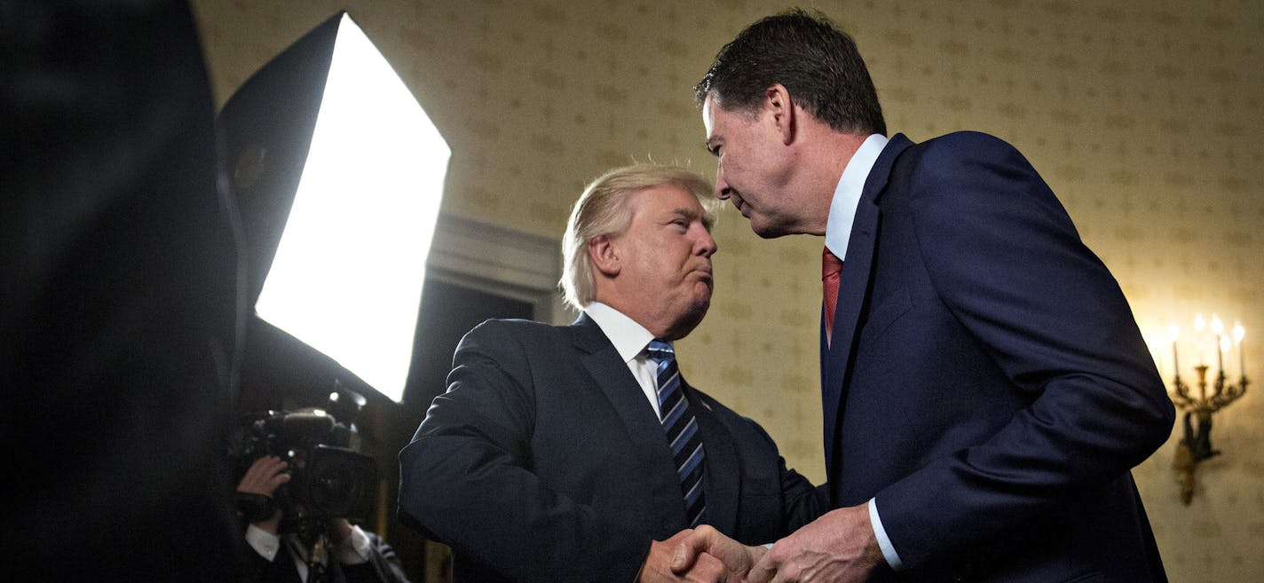 President Donald Trump, left, shakes hands with James Comey, then director of the Federal Bureau of Investigation, in the Blue Room of the White House in Washington, D.C., on January 22, 2017. Trump on June 16 lashed out at the Justice Department official with authority over the special counsel probe of Russian election-meddling, and acknowledged that his firing of Comey as FBI director is a focus of the investigation. (Andrew Harrer/Pool/Sipa USA/TNS) ORG XMIT: 1228496