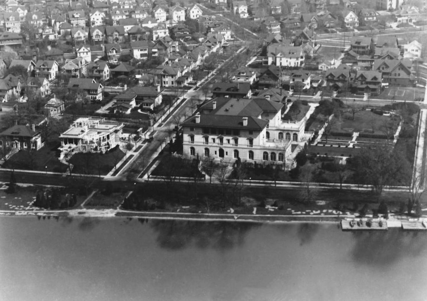 An aerial photo of the Gates Mansion from around 1930 shows 25th St. on the left of it and Lake of the Isles in front of it. The house across 25th Street is still there today.