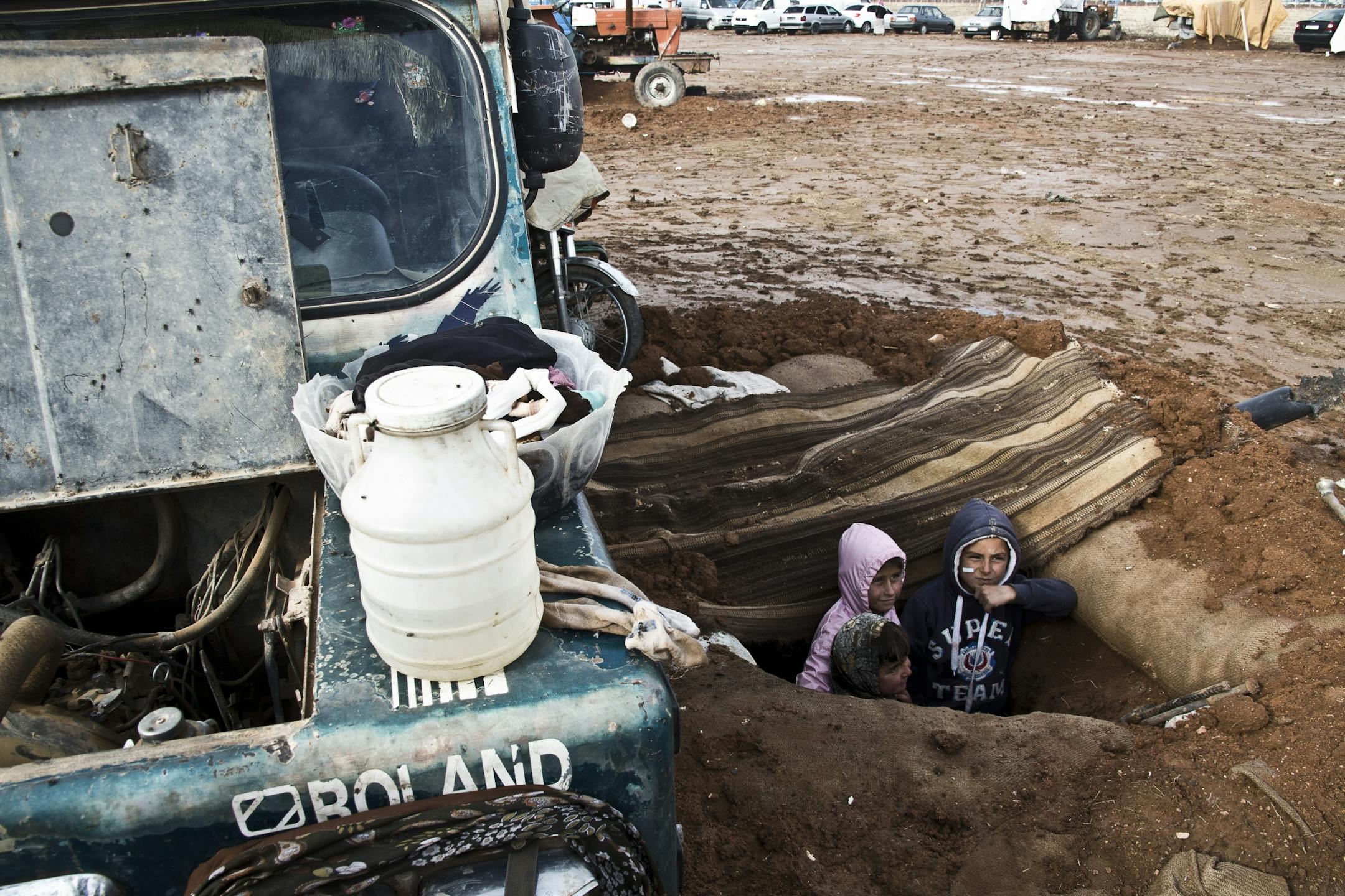 In this Saturday, Nov. 22, 2014 photo, children stand in a trench built for mortar attacks by Islamic State group fighters against the civilians in the buffer zone near the Turkish border in Kobani, Syria. Here, Kurdish fighters backed by small numbers of Iraqi peshmerga forces and Syrian rebels, are locked in what they see as an existential battle against the Islamic State group, who swept into their town in mid-September as part of a summer blitz after the Islamic State group overran large par