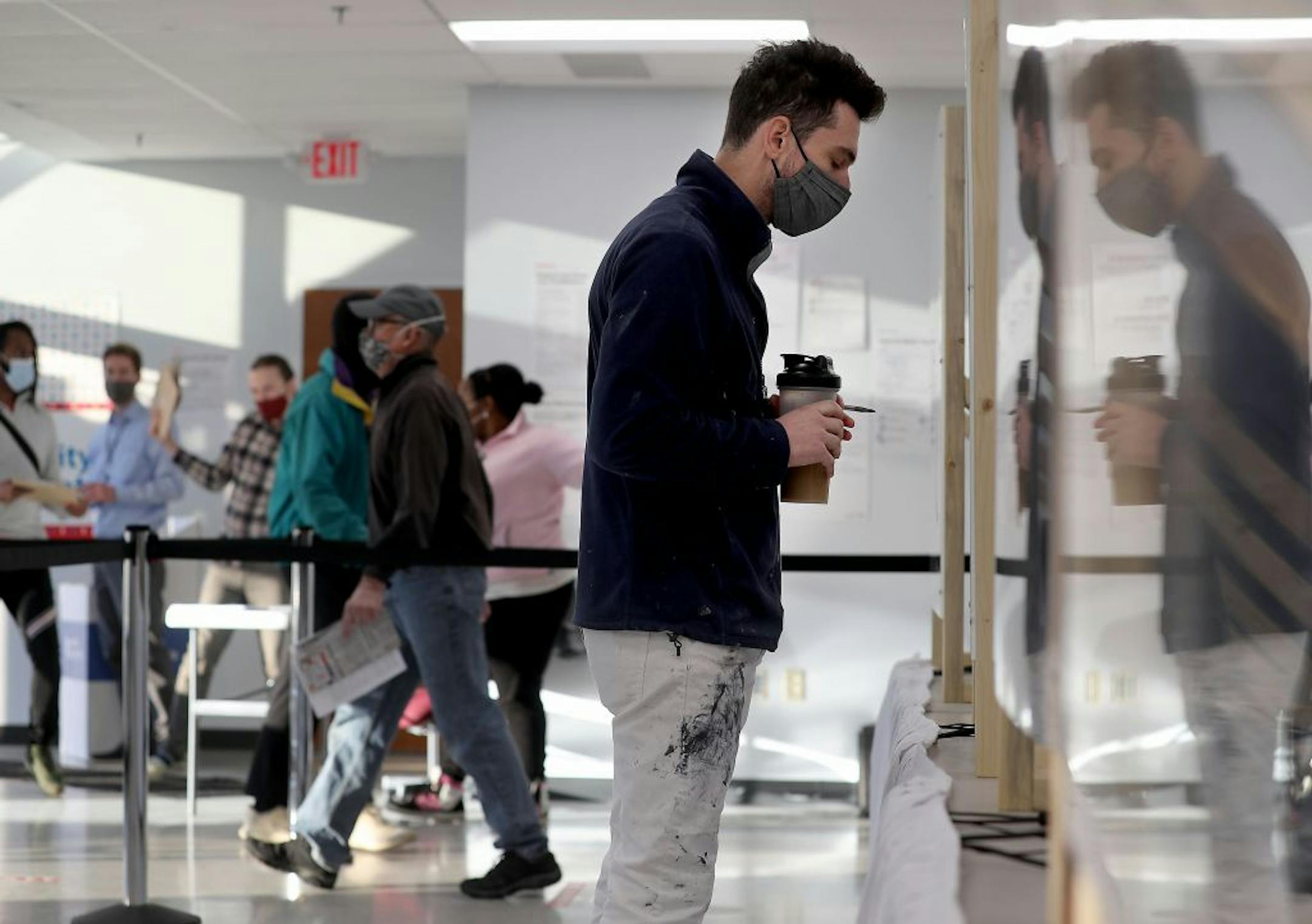 Jason Miller of Minneapolis, who was the first in line for early voting, waited to receive his ballot at Minneapolis Elections and Voter Services Friday in Minneapolis.