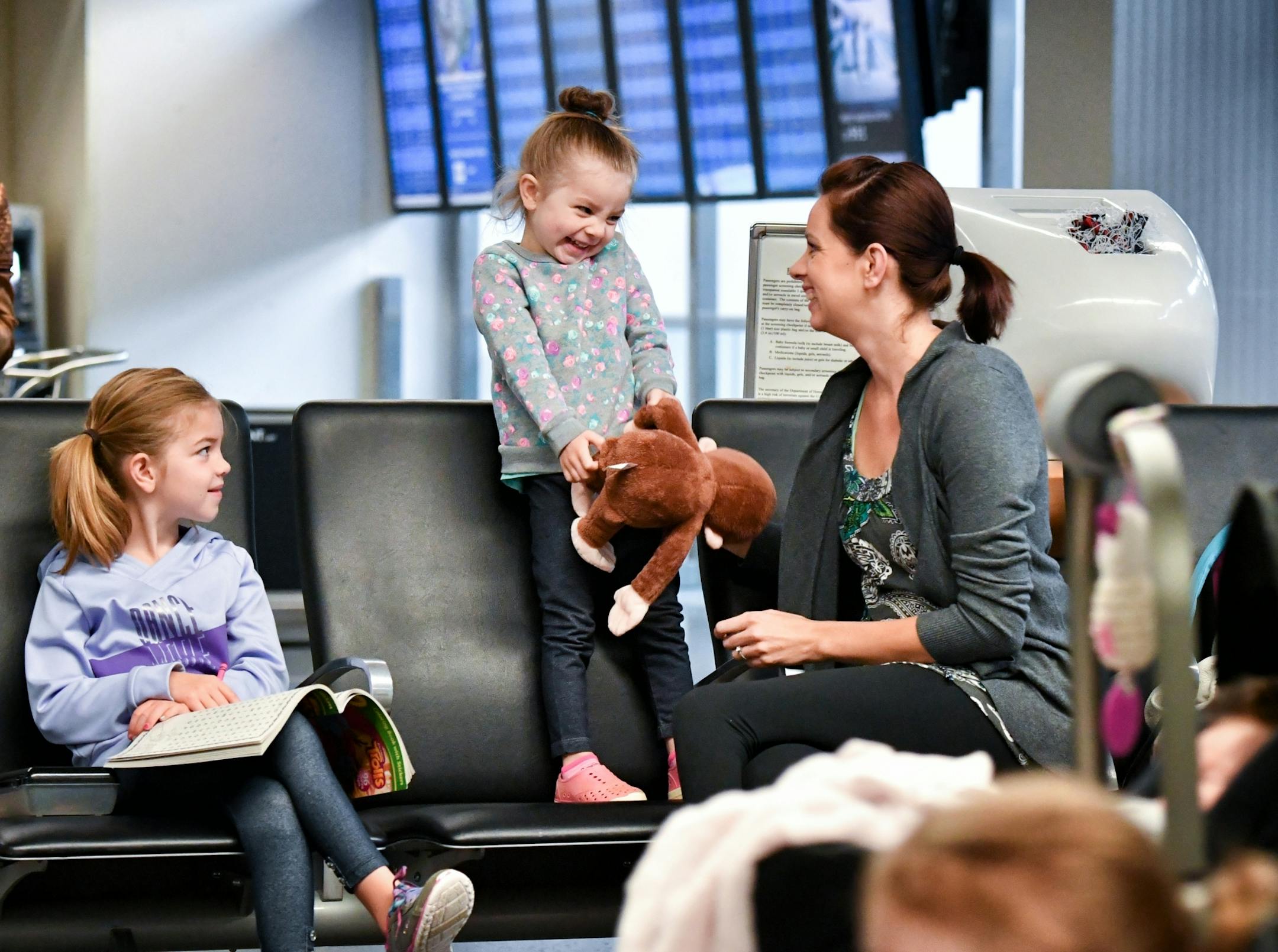 Kandice Cogbill kept her daughters Amelia, 3 and Malorie, 6, busy while her husband parked their car before heading to Phoenix. Travelers check into their flights Friday morning at Minneapolis St. Paul International Airport Terminal 1.