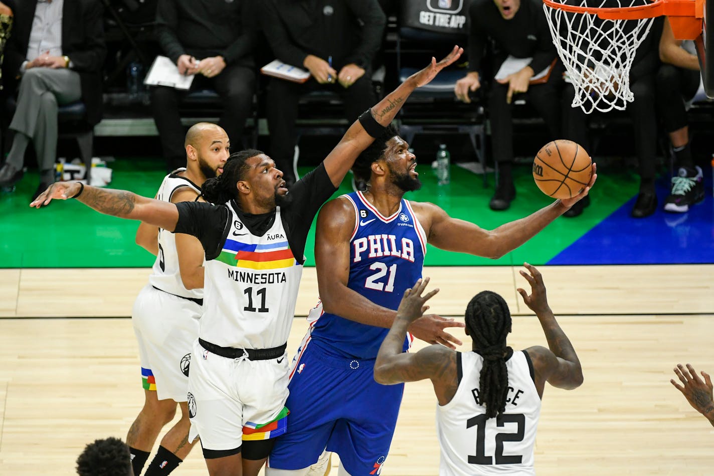 Philadelphia 76ers center Joel Embiid (21) goes up for a shot past Minnesota Timberwolves center Naz Reid (11) during the second half of an NBA basketball game Tuesday, March 7, 2023, in Minneapolis. Embiid had 39 points as Philadelphia won 117-94. (AP Photo/Craig Lassig)