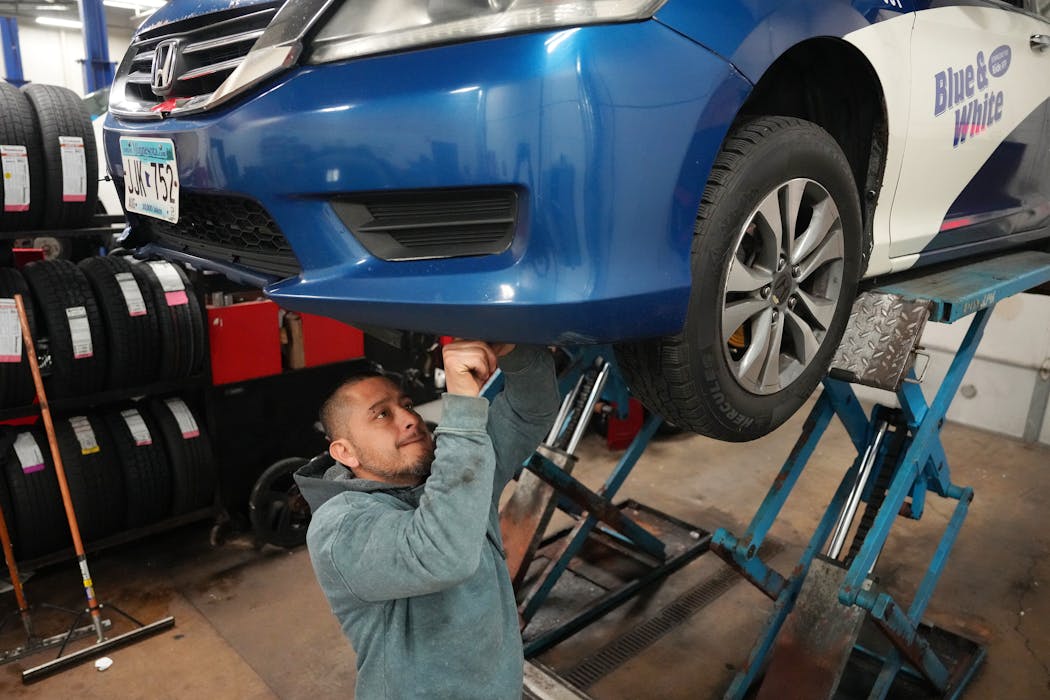 Technician Cesar Orihuela repairs the front end of a fleet vehicle Wednesday at Blue & White Cab in St. Louis Park.