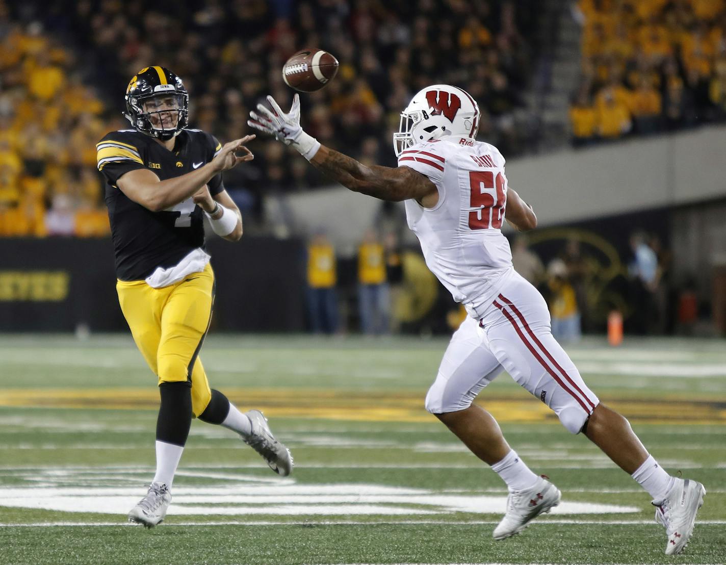 Iowa quarterback Nate Stanley, left, throws the ball as Wisconsin linebacker Zack Baun, right, pressures during the second half of an NCAA college football game, Saturday, Sept. 22, 2018, in Iowa City. (AP Photo/Matthew Putney)