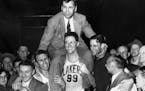 George Mikan (99) hoisted coach John Kundla after the Lakers won their third NBA title in four seasons in 1952.
