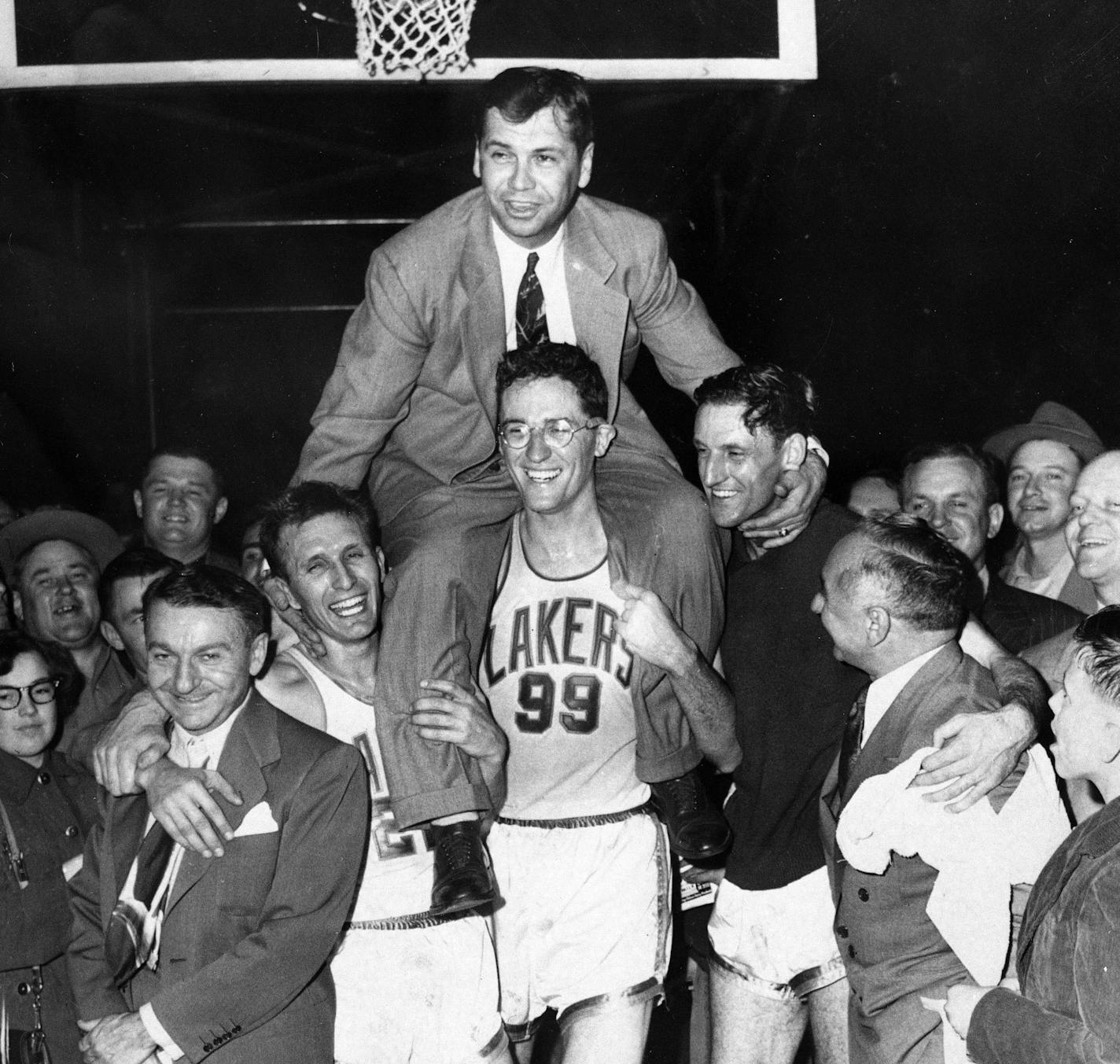 George Mikan (99) hoisted coach John Kundla after the Lakers won their third NBA title in four seasons in 1952.