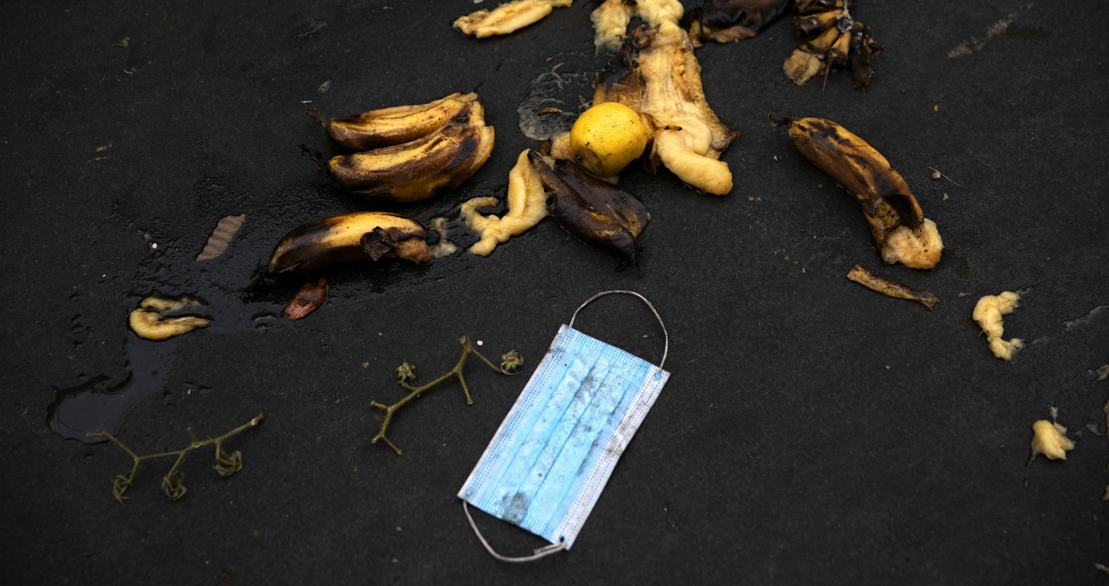 A face mask is seen amongst waste thrown on the ground at a closed market on the first day of the three-week nationwide lockdown, in Tel Aviv, Israel, Friday, Sept 18, 2020. Israel went back into a full lockdown on Friday to try to contain a coronavirus outbreak that has steadily worsened for months as its government has been plagued by indecision and infighting. (AP Photo/Oded Balilty)