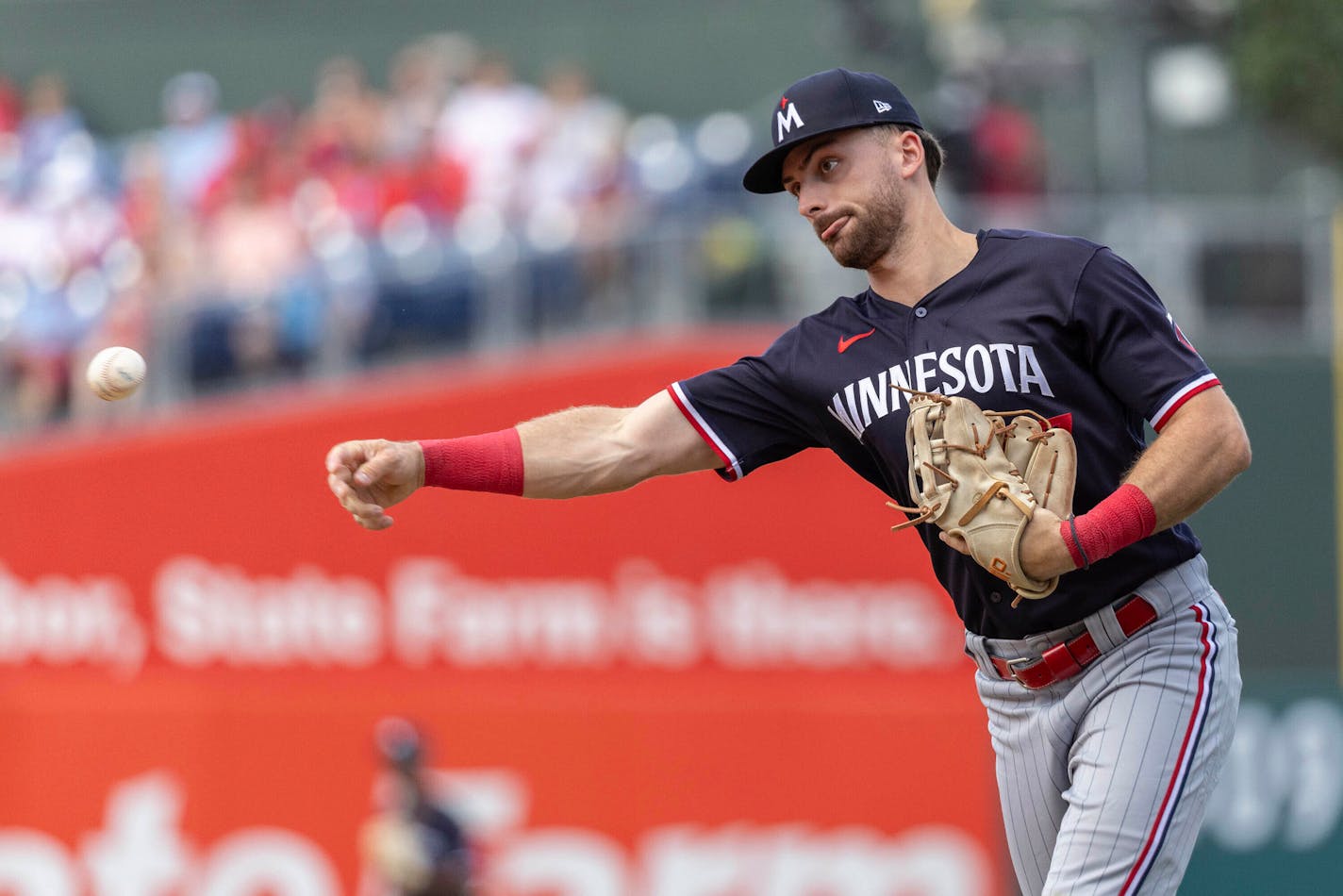 Minnesota Twins second baseman Edouard Julien throws to first base for an out against Philadelphia Phillies' Jake Cave during the fourth inning of a baseball game, Sunday, Aug. 13, 2023, in Philadelphia. (AP Photo/Laurence Kesterson)