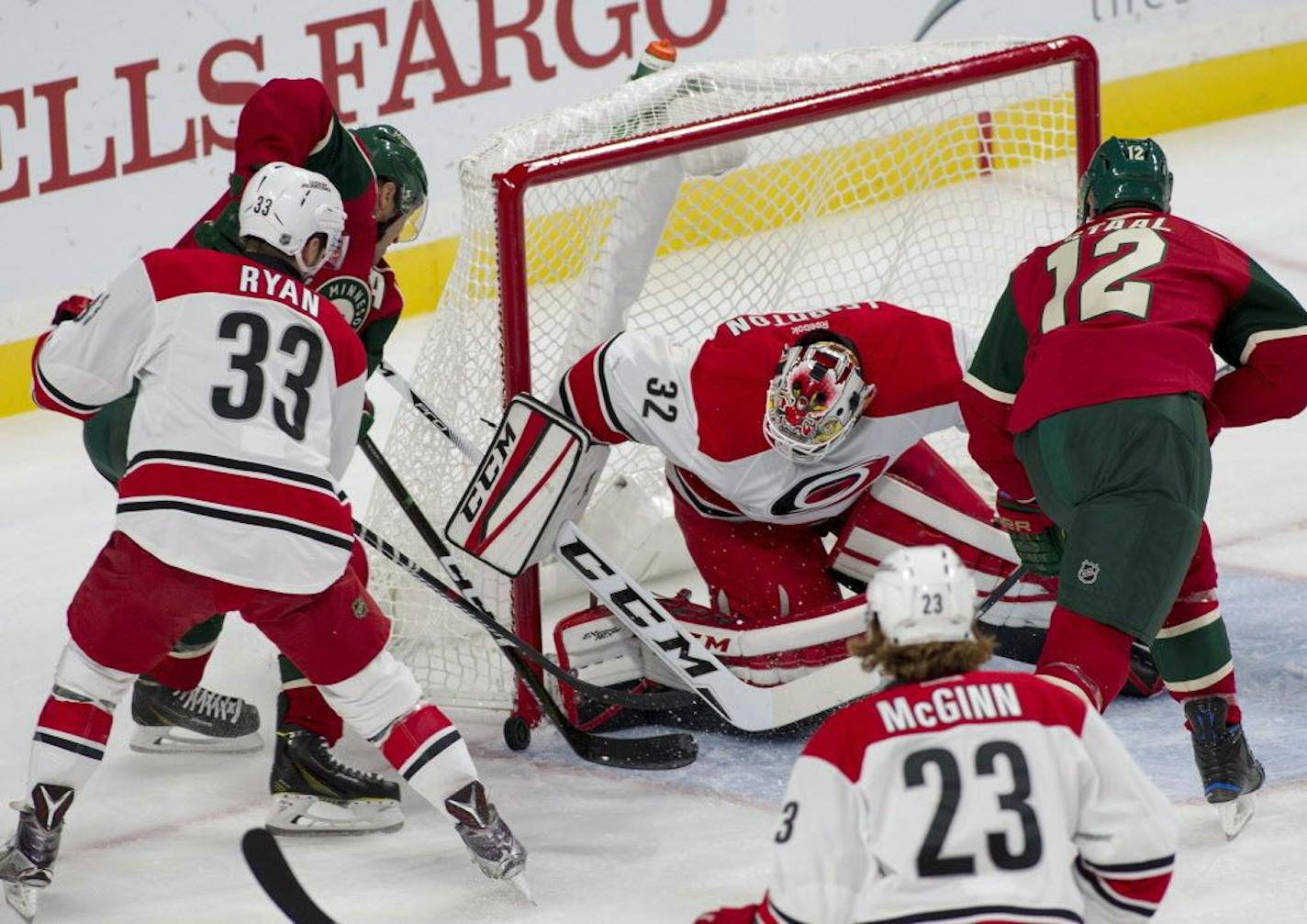 Minnesota Wild left wing Zach Parise (11) works in close against Carolina Hurricanes goalie Michael Leighton (32) as Carolina Hurricanes center Derek Ryan (33) defends during the first period of an NHL preseason game, Sunday, Oct. 2, 2016, in St. Paul, Minn. Minnesota Wild center Eric Staal (12) looks on.