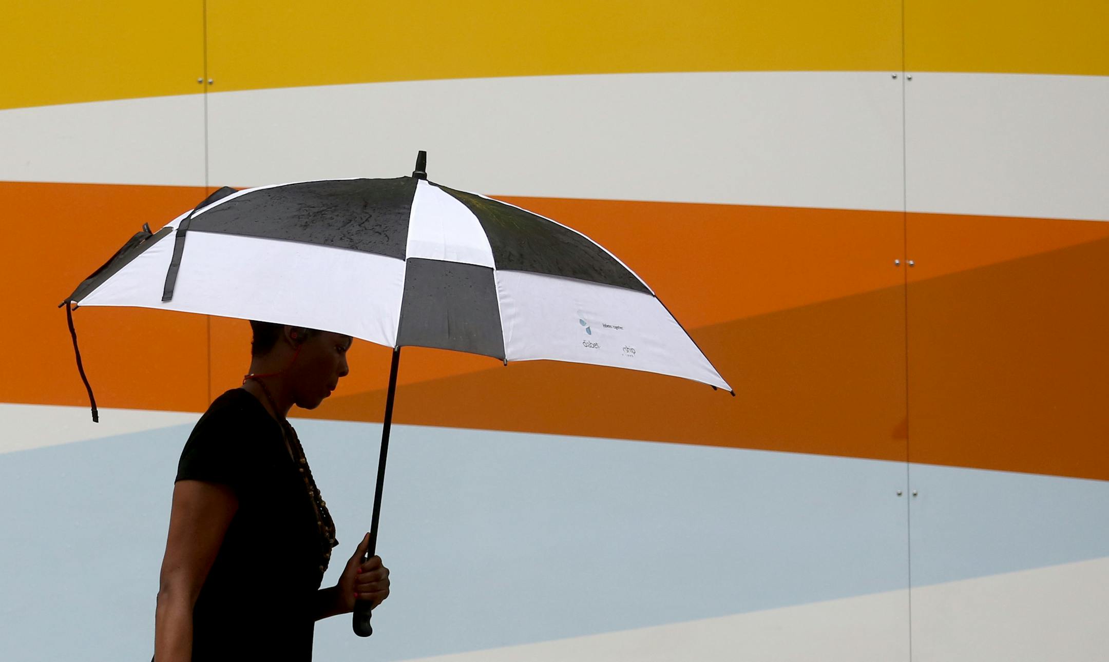 A pedestrian tried to keep dry while walking down Nicollet Mall. ] (KYNDELL HARKNESS/STAR TRIBUNE) kyndell.harkness@startribune.com Weather in downtown Minneapolis , Min., Thursday, June 11, 2015.