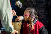 Alegria Walker, 4, a descendant of the Mille Lacs Band of Ojibwe, takes a sip of water during a water ceremony on Indigenous Peoples’ Day at Ȟaȟa 