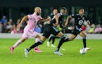 Inter Miami forward Gonzalo Higuaín, left, tries to make it past Minnesota United midfielder Kervin Arriaga (33) during the first half of an MLS socc
