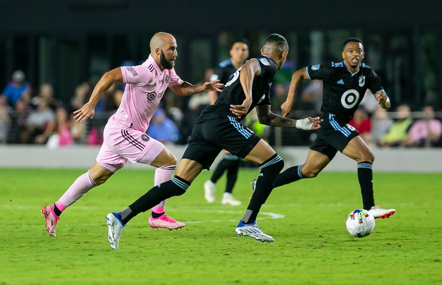 Inter Miami forward Gonzalo Higuaín, left, tries to make it past Minnesota United midfielder Kervin Arriaga (33) during the first half of an MLS soccer match Saturday, June 25, 2022, in Fort Lauderdale, Fla. (Matias J. Ocner/Miami Herald via AP)