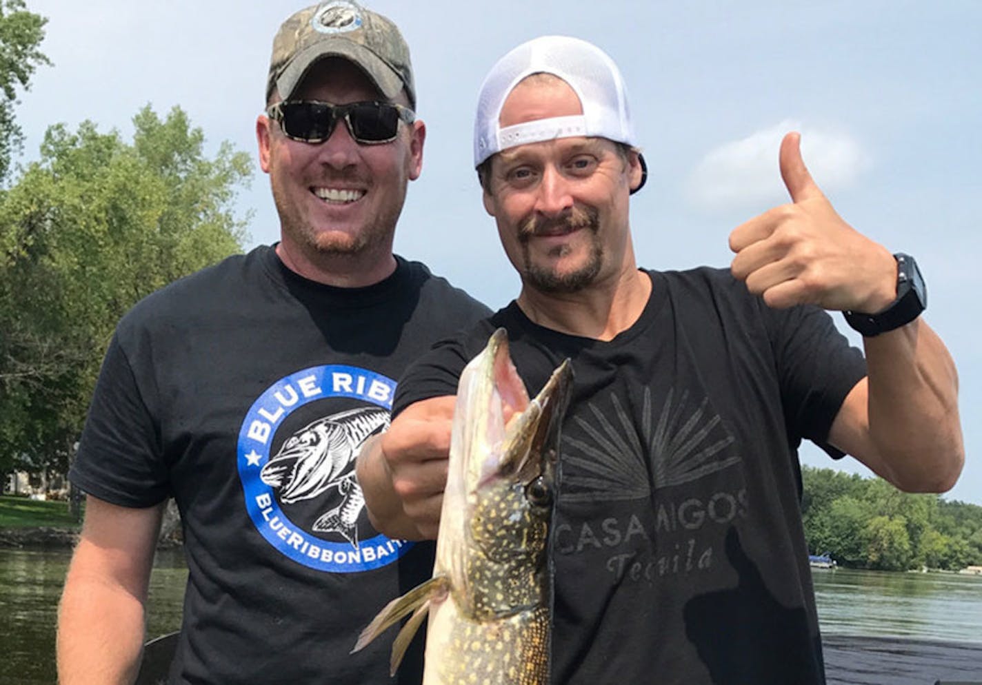 Twin Cities fishing guide Josh Stevenson, left, with Kid Rock and a northern pike he caught Sunday after appearing at Grand Casino in Hinckley and before flying to a gig that night at the Iowa State Fair.