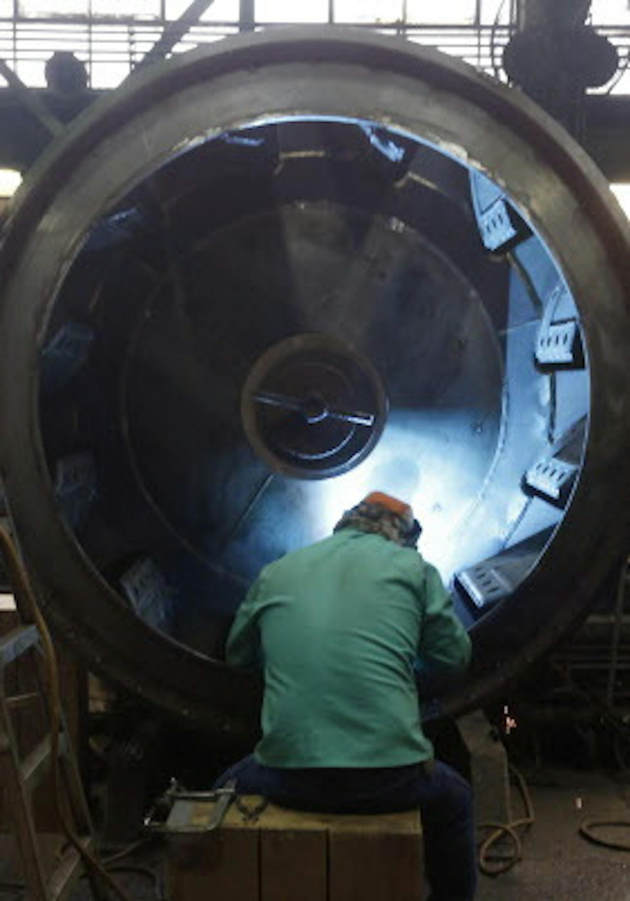 In this photo made on Thursday, Feb. 12, 2015, a man welds parts in fans for industrial ventilation systems at the Robinson Fans Inc. plant in Harmony, Pa. The Commerce Department releases fourth-quarter gross domestic product on Friday, March 27, 2015. (AP Photo/Keith Srakocic)