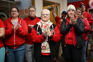 Members of the St. Paul Federation of Educators bargaining team, including Rene Myers, center, and Davia Christiansen, right, celebrate their tentativ