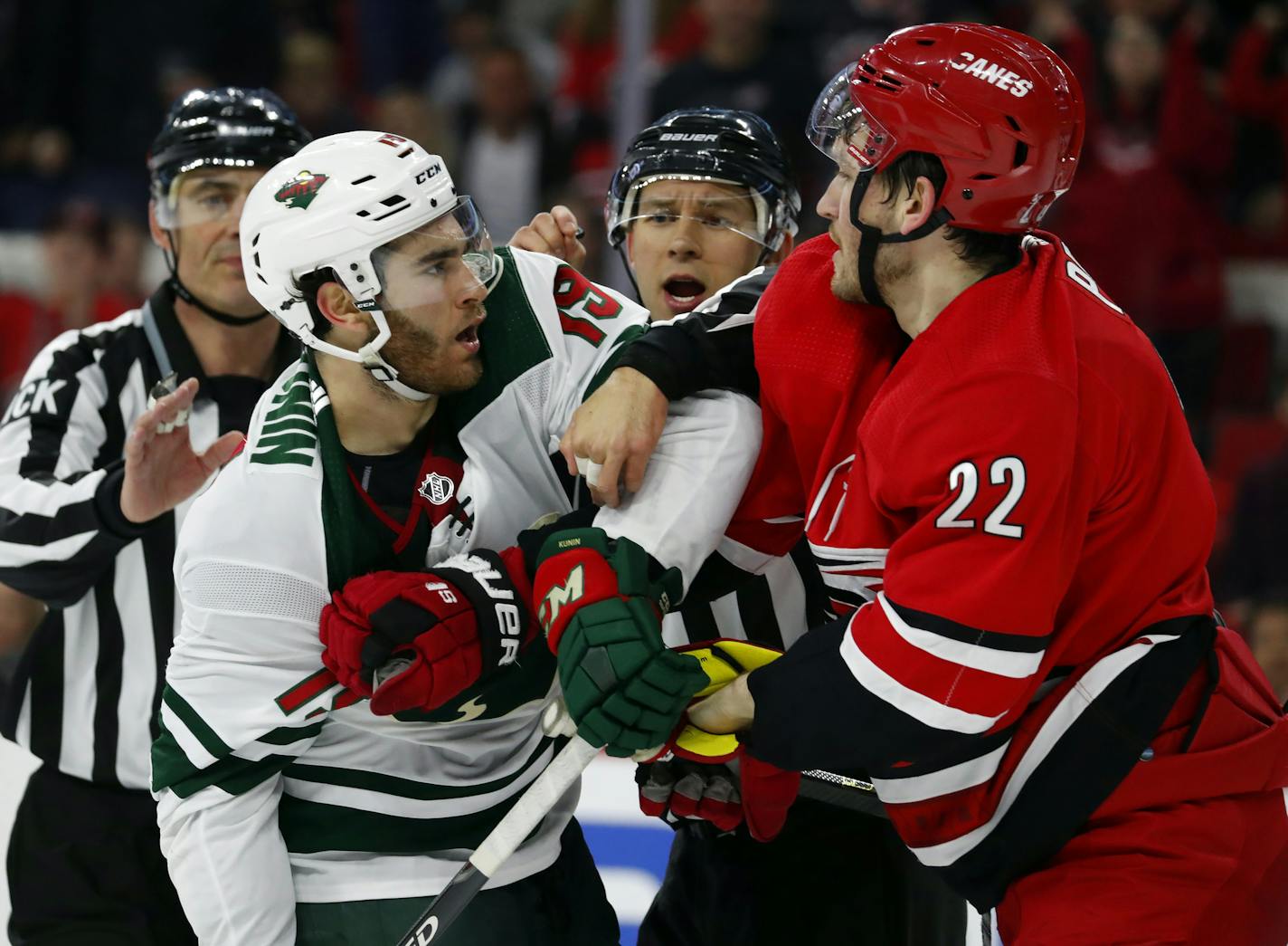 Carolina Hurricanes' Brett Pesce (22) fights with Minnesota Wild's Luke Kunin (19) during the third period of an NHL hockey game, Saturday, March 23, 2019, in Raleigh, N.C. (AP Photo/Karl B DeBlaker)