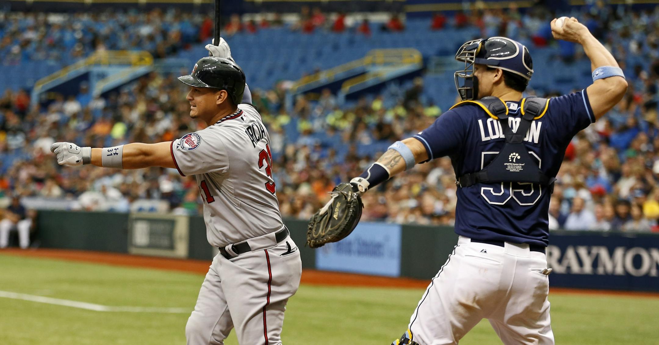 Minnesota Twins' Oswaldo Arcia, left, strikes out in front of Tampa Bay Rays catcher Jose Lobaton during the ninth inning of a baseball game Thursday, July 11, 2013, in St. Petersburg, Fla. The Rays won 4-3.