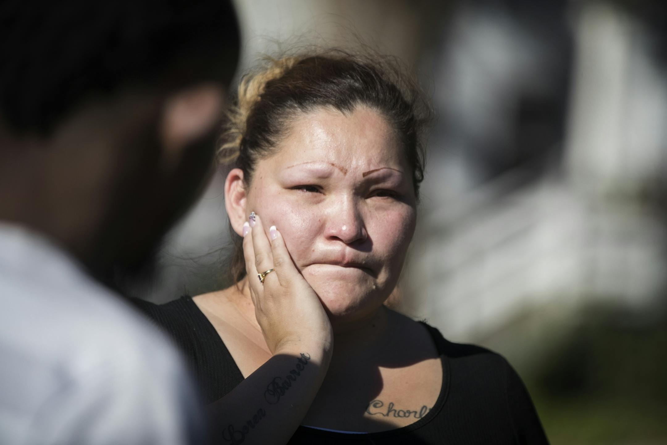 Julia Johnson, the sister of the adult male victim, waits at the scene of the shooting.