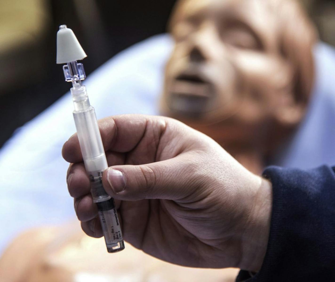 ADVANCE FOR USE SUNDAY, APRIL10 AND THEREAFTER - In this March 16, 2016 photo, Chris Humor, a paramedic with Carle Arrow Ambulance in Champaign, Ill., holds a syringe with a mist atomizer used to dispense Narcan, the emergency, life-saving opiate antidote for heroin overdose victims. (John Dixon/The News-Gazette via AP) MANDATORY CREDIT