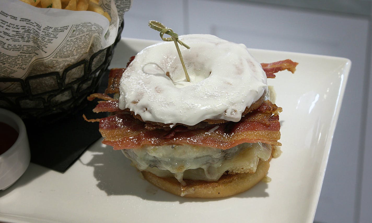 Outta Control: The Sugar Factory in the Mall of America. The Donut Burger is a 8-ounce beef patty and a grilled cheese sandwich stacked between two doughnuts dripping with white glaze. There&#xd5;s cheese, there&#xd5;s bacon, there&#xd5;s powdered sugar. Friday, Dec. 20, 2019, Bloomington, MN. ] Matt Gillmer / matt.gillmer@startribune.com